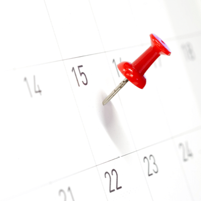 Embroidered red pins on a calendar on the 15th with selective focus