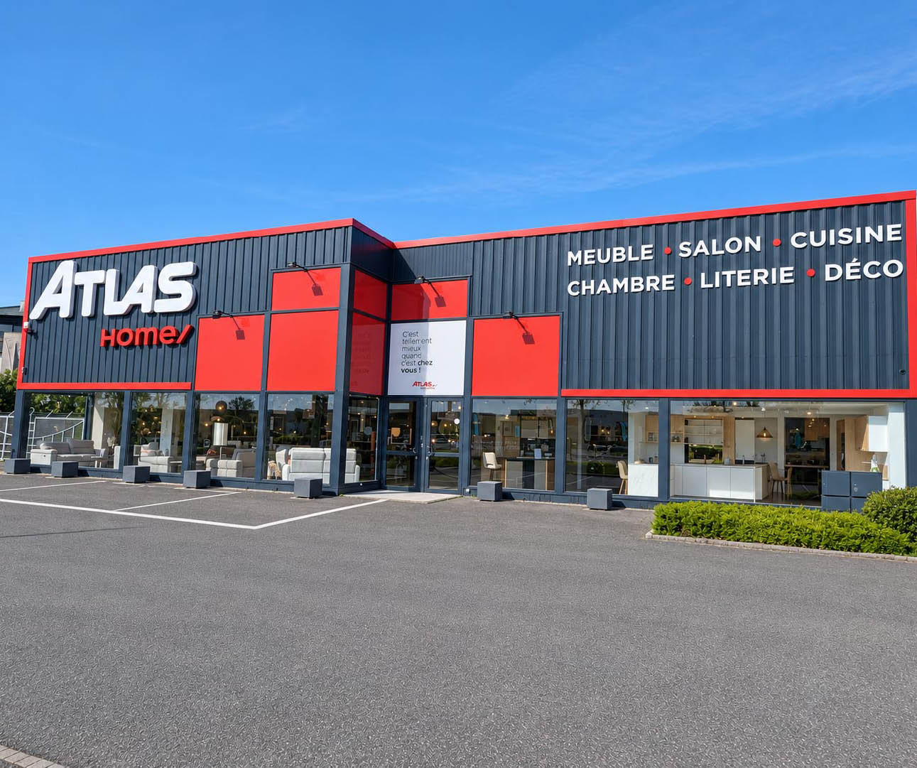 Fa ade moderne d'un magasin de meubles avec des panneaux rouges et noirs et des fen tres vitr es laissant voir des canap s et des luminaires  l'int rieur.  Description g n r e par IA