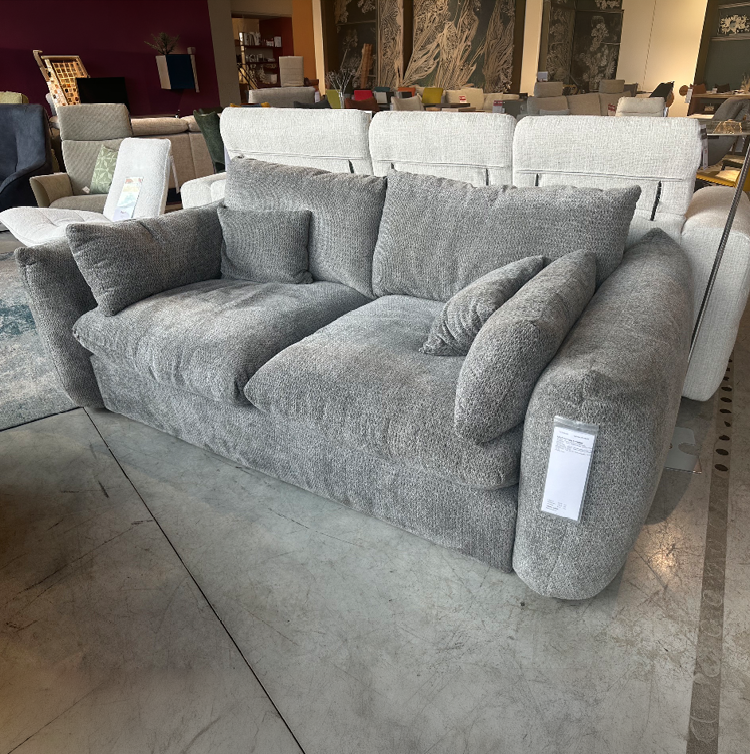 Canap gris en tissu avec plusieurs coussins assortis expos  dans un magasin de meubles.  Description g n r e par IA