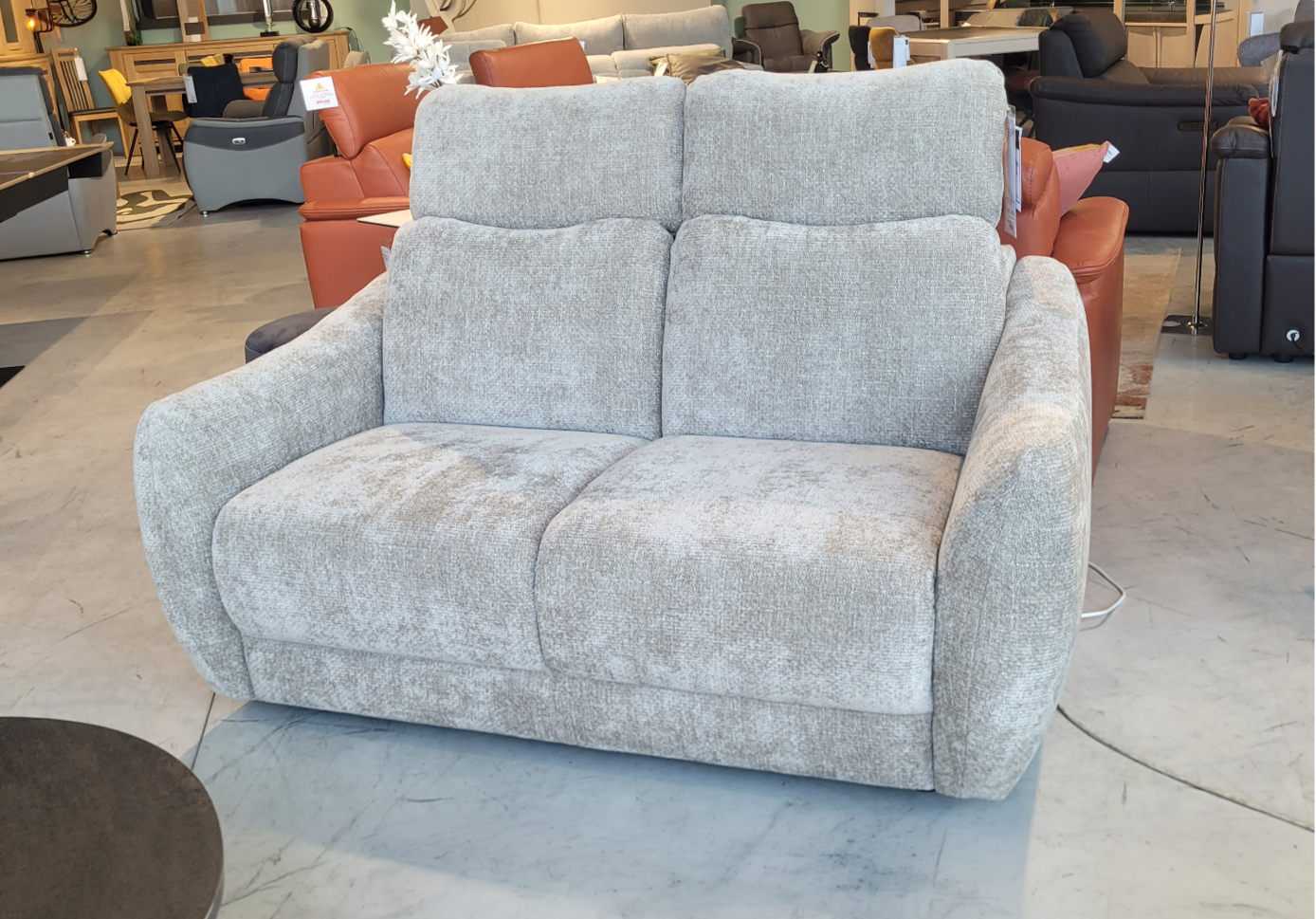 Fauteuil relax en tissu marron clair avec t l commande pos dans un int rieur moderne pr s d'une grande fen tre et d'une cloison en bois d corative.  Description g n r e par IA