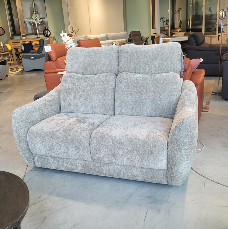 Fauteuil relax gris avec une t l commande pos e sur l'accoudoir dans un int rieur moderne pr s d'une grande fen tre et d'une cloison en bois d corative. Description g n r e par IA