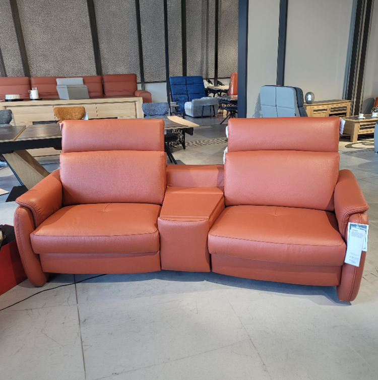 Fauteuil relax gris avec une t l commande pos e sur l'accoudoir dans un int rieur moderne pr s d'une grande fen tre et d'une cloison en bois d corative. Description g n r e par IA