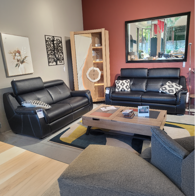 Fauteuil relax gris avec une t l commande pos e sur l'accoudoir dans un int rieur moderne pr s d'une grande fen tre et d'une cloison en bois d corative. Description g n r e par IA