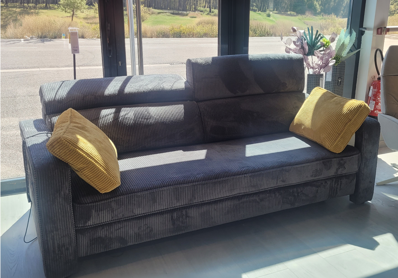 Fauteuil relax en tissu marron clair avec t l commande pos dans un int rieur moderne pr s d'une grande fen tre et d'une cloison en bois d corative.  Description g n r e par IA