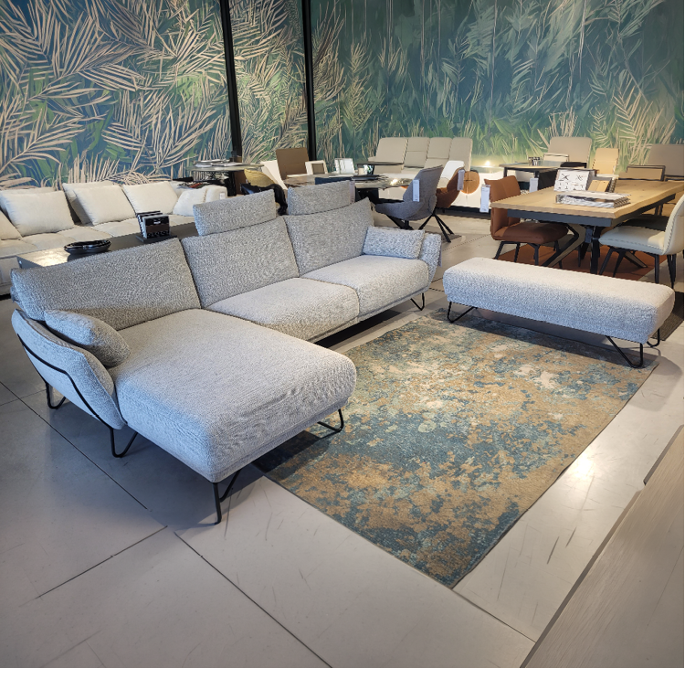 Fauteuil relax gris avec une t l commande pos e sur l'accoudoir dans un int rieur moderne pr s d'une grande fen tre et d'une cloison en bois d corative. Description g n r e par IA