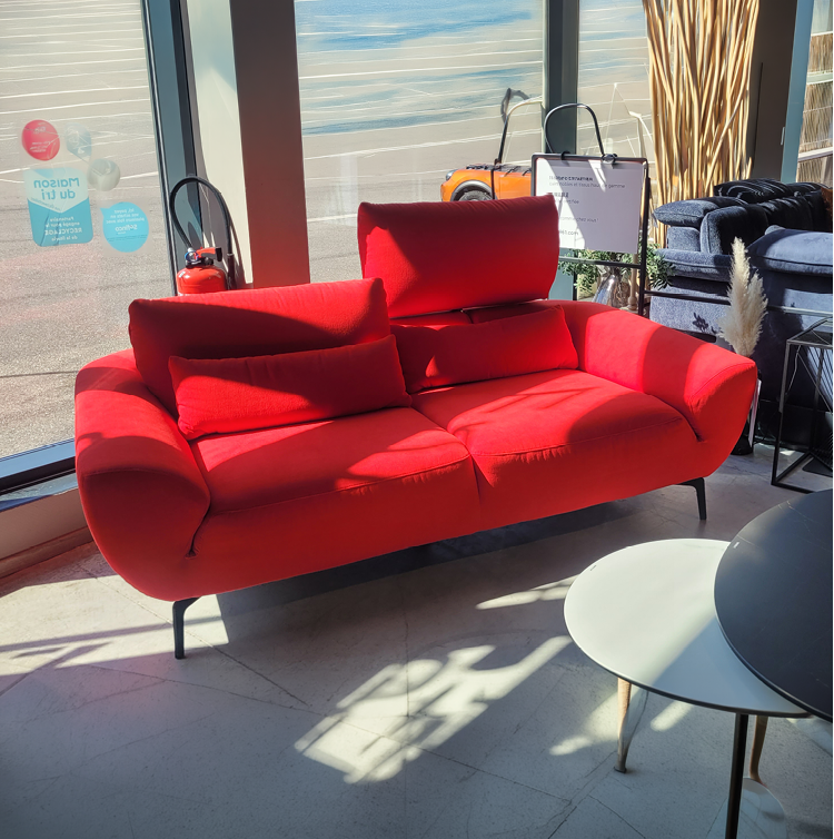 Fauteuil relax gris avec une t l commande pos e sur l'accoudoir dans un int rieur moderne pr s d'une grande fen tre et d'une cloison en bois d corative. Description g n r e par IA