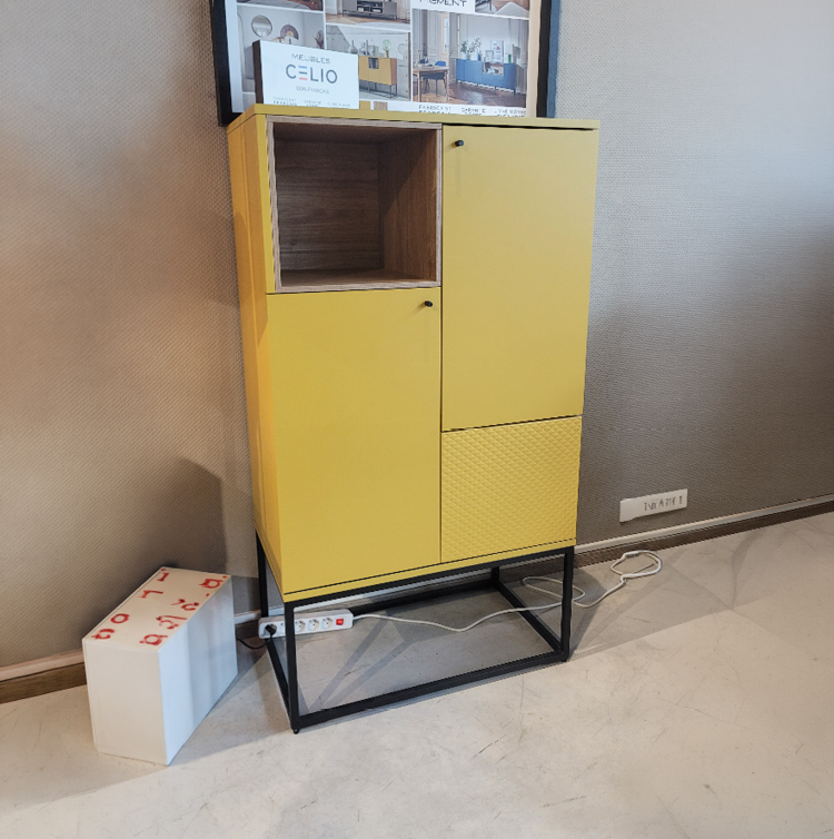 Meuble bas en bois clair avec une porte jaune et une tag re ouverte, surmont  de panneaux publicitaires pr sentant des meubles modernes et color s.  Description g n r e par IA