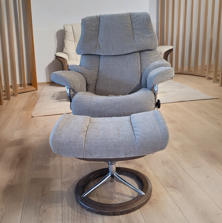 Fauteuil gris avec repose-pieds assorti dans une pi ce au sol en bois clair et murs avec des panneaux verticaux en bois. Description g n r e par IA