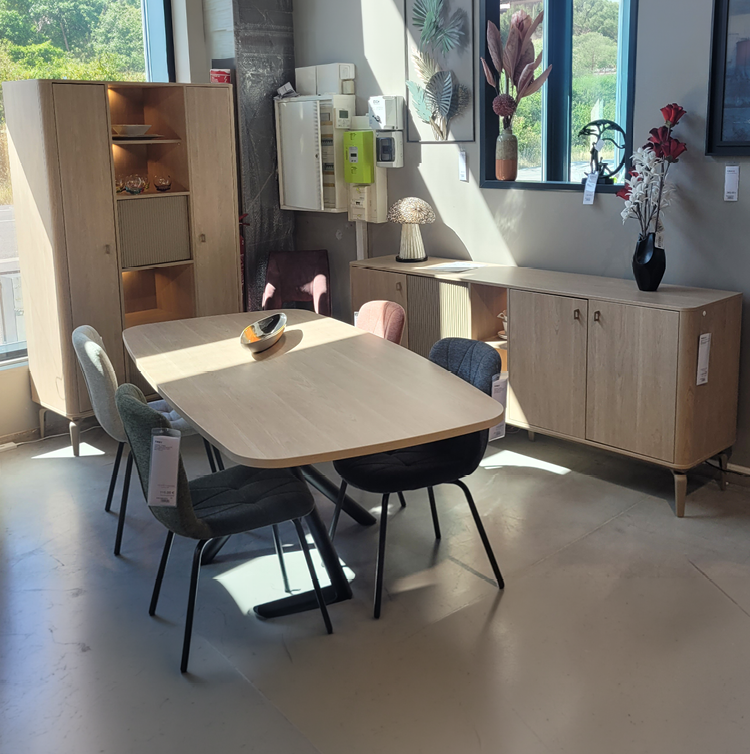 Une pi ce lumineuse avec une table, des chaises, un meuble en bois, un tableau d coratif de feuilles, une lampe de table et un vase avec des fleurs pr s d'une fen tre. Description g n r e par IA