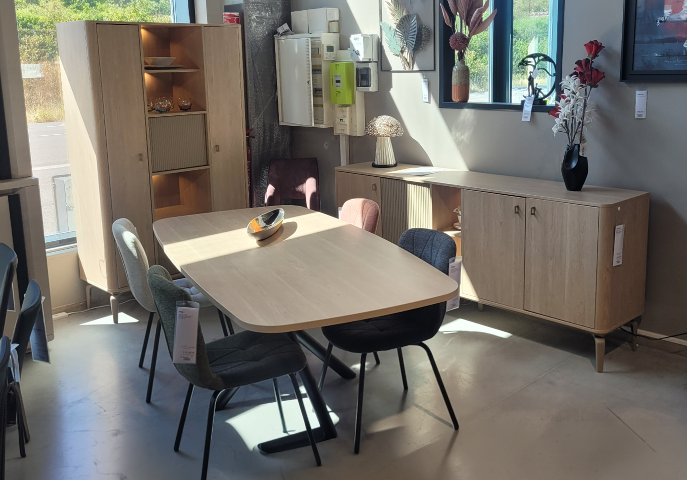Une pi ce lumineuse avec une grande fen tre, un meuble en bois, une table avec des chaises, une lampe d corative en forme de champignon et des objets d coratifs sur les murs et les meubles. Description g n r e par IA