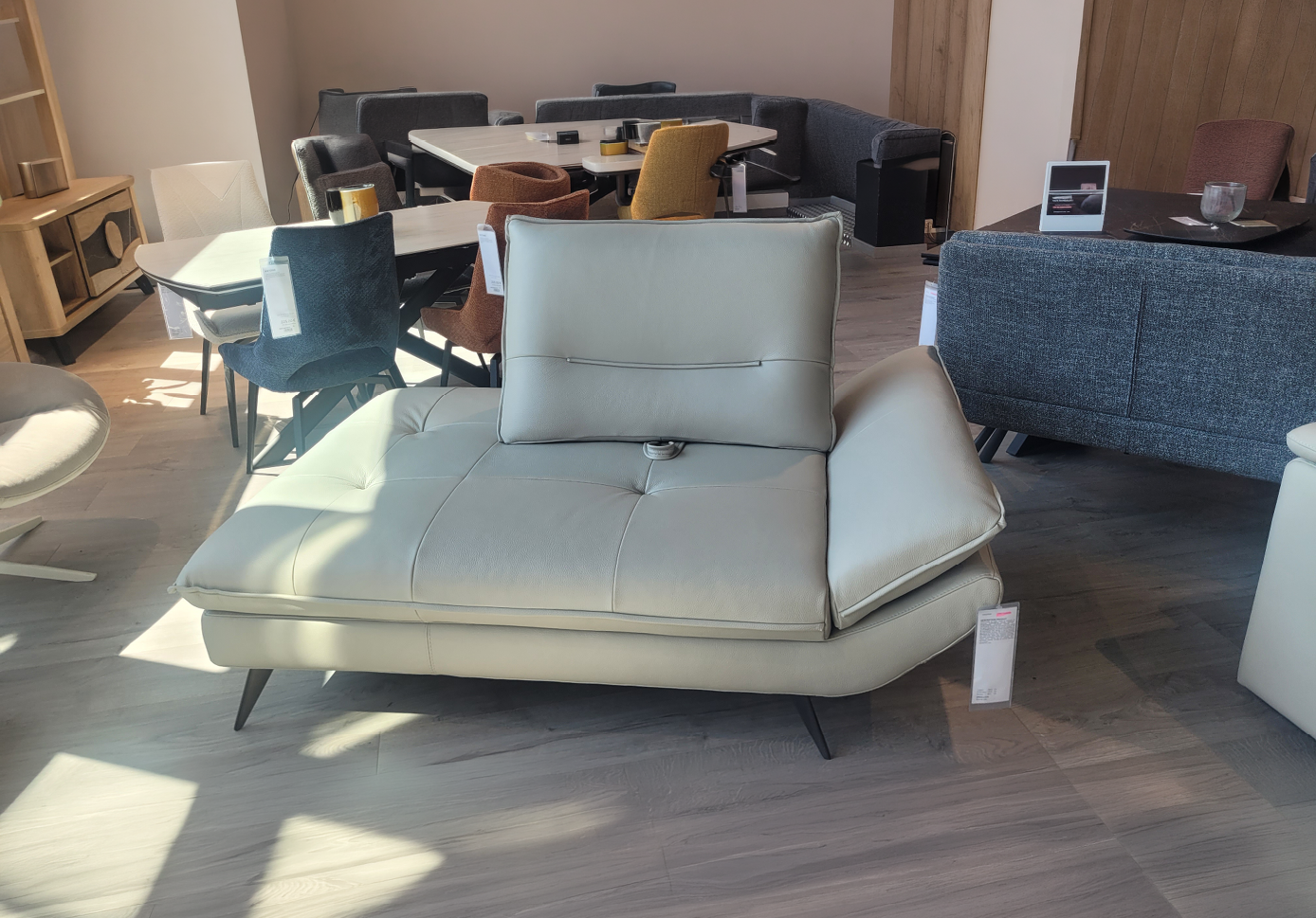 Canap moderne en cuir beige avec dossier ajustable dans un showroom de meubles lumineux.  Description g n r e par IA