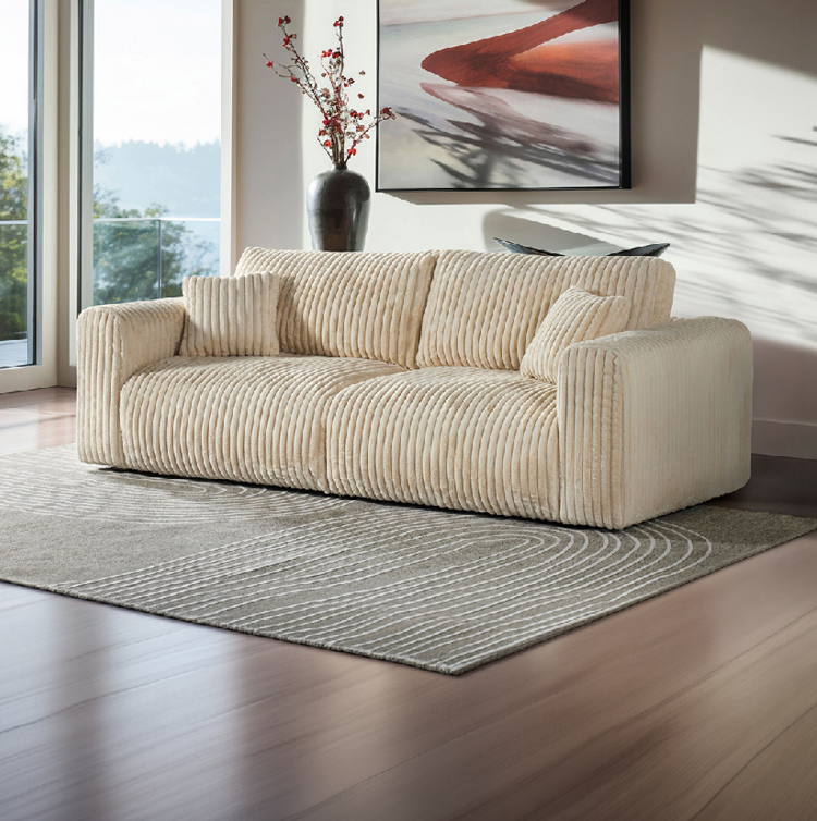 Canap beige en tissu c tel  avec deux coussins assortis dans un salon lumineux d cor  d'un vase noir avec des fleurs rouges et d'un tableau abstrait.  Description g n r e par IA